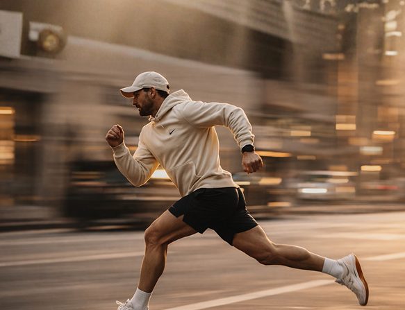 A man sprinting down a city street at golden hour